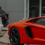 Luxury Cars - Close-up of a red sports car parked in an urban #12565903