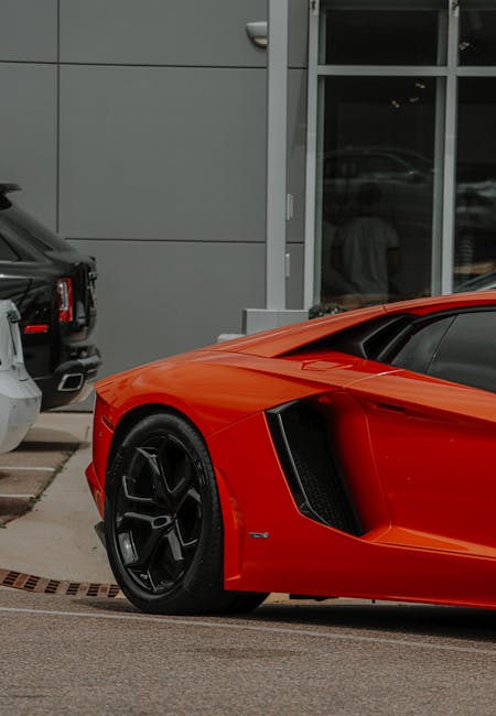 Luxury Cars - Close-up of a red sports car parked in an urban #12565903