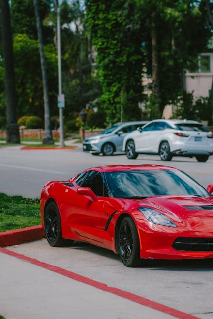 Luxury Cars - Red sports car parked on a tree-lined street sho #16735457