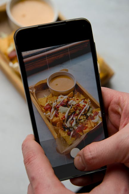 Food Aesthetics - Hand holding smartphone capturing a photo of nac #20270642
