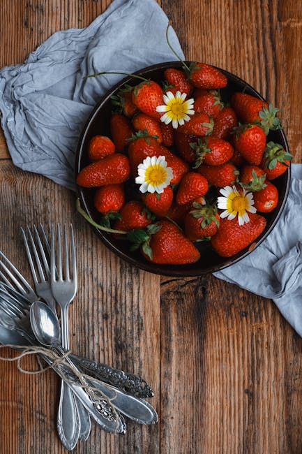 Food Aesthetics - A bowl of fresh strawberries with daisies on a r #23913653