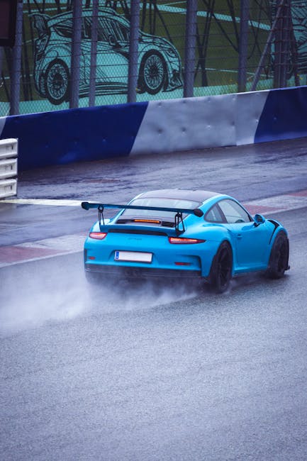 Luxury Cars - A sporty blue car speeds on a wet race track, ca #27513471