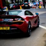 Luxury Cars - A sleek red supercar parked on a bustling street #6152807