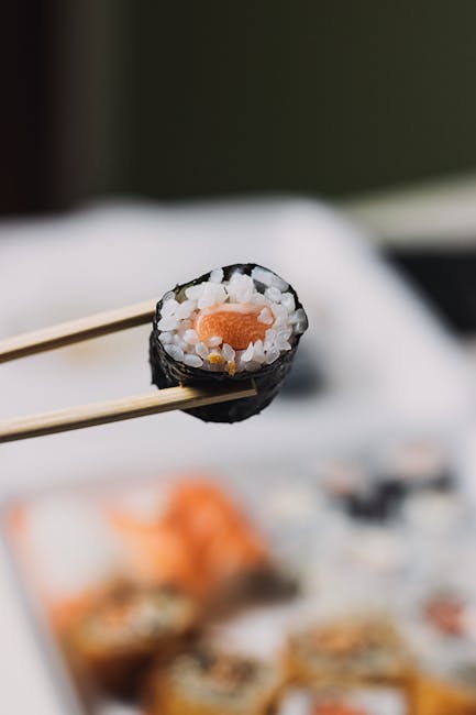 Food Aesthetics - Close-up of sushi roll with chopsticks in a blur #7717517